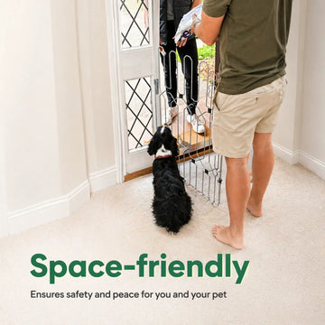 Man opening the front door while a dog waits behind the dog gate